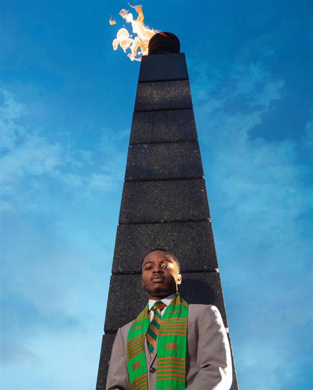 Man standing in front of FAMU's eternal flame.