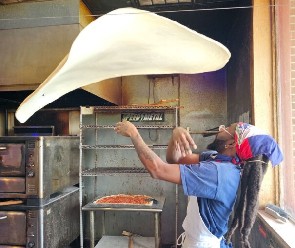 man tossing pizza at Momo's pie in the sky