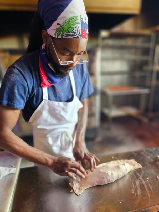 man making a calzone at momo's pizza