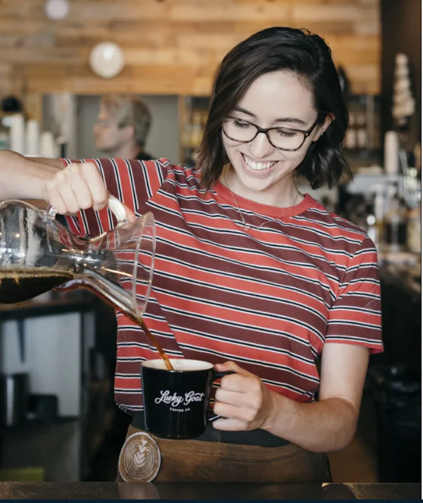 woman serves pour over coffee at Lucky goat