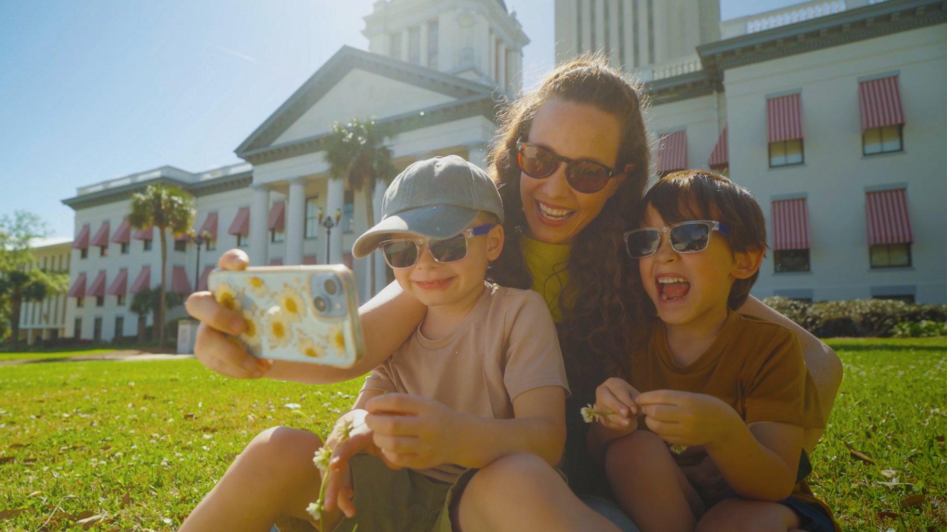 family taking selfie at the capitol of florida in the grass